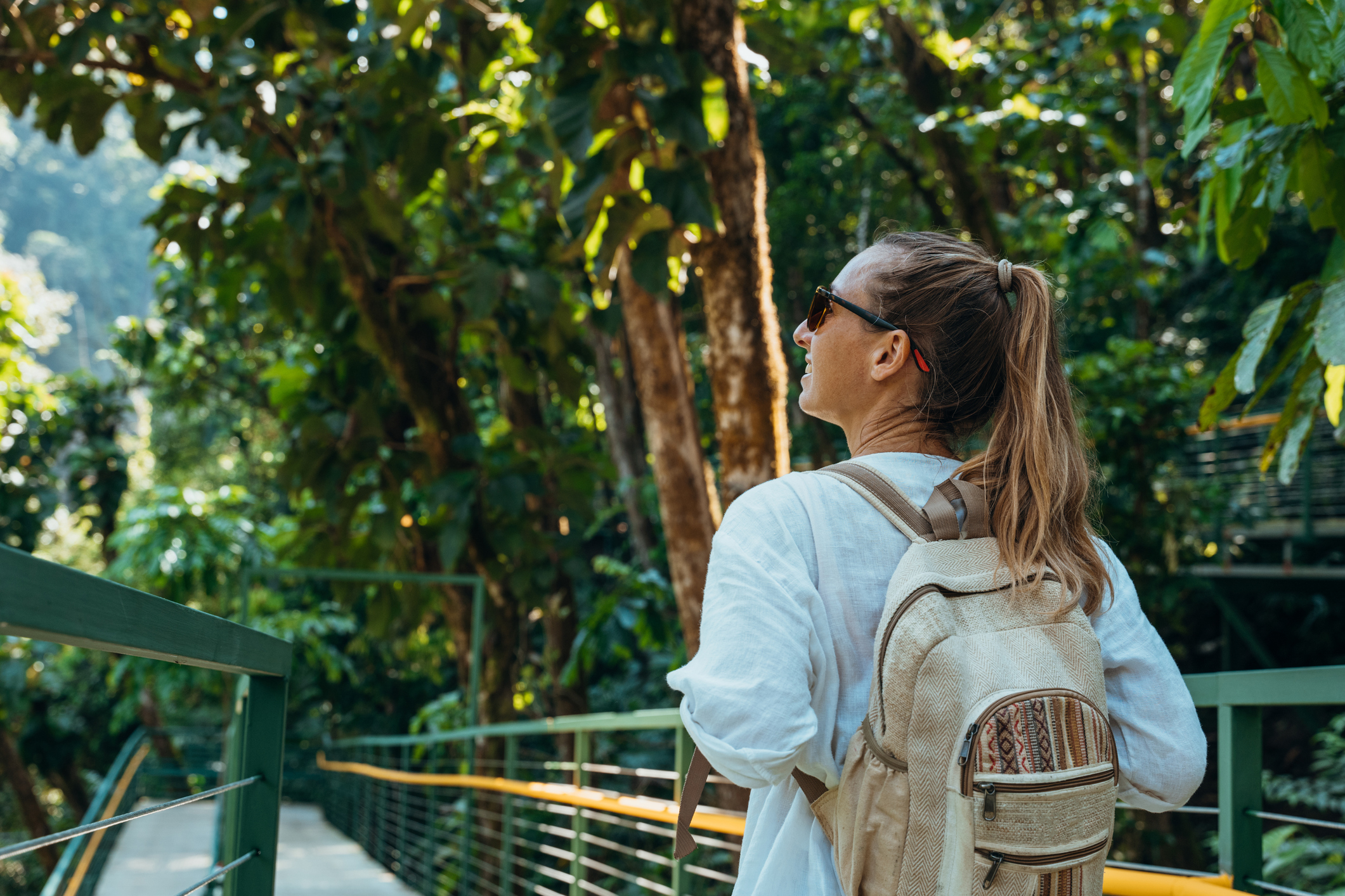 Woman Walking on Elevated Forest Trail with Backpack